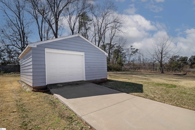 detached garage featuring driveway and fence