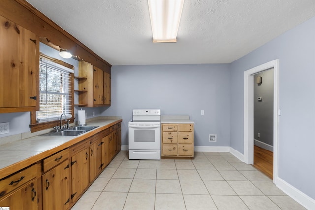 kitchen with tile countertops, electric range, light tile patterned flooring, and a sink