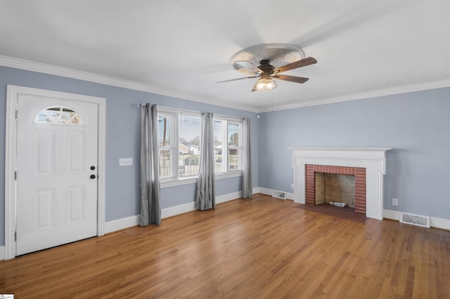 unfurnished living room featuring a brick fireplace, visible vents, and wood finished floors