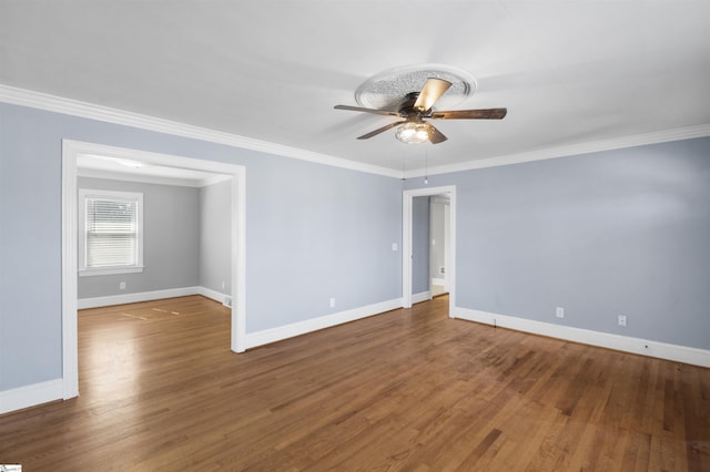 spare room with ornamental molding, wood finished floors, and baseboards