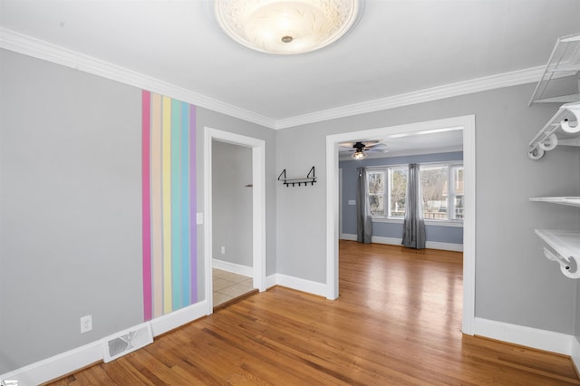 interior space featuring ornamental molding, visible vents, light wood-style floors, and baseboards