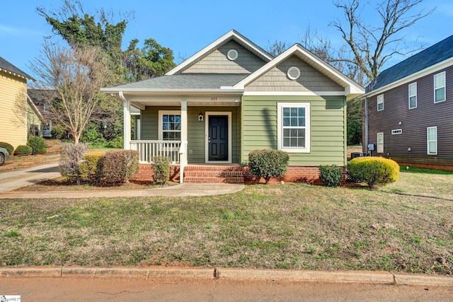 bungalow-style house featuring covered porch and a front lawn