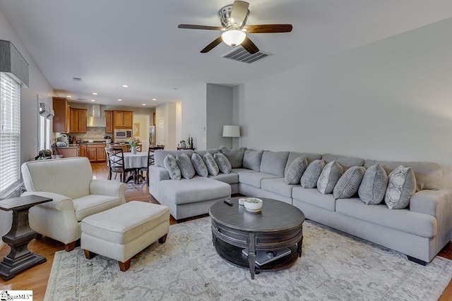 living room featuring recessed lighting, visible vents, ceiling fan, and light wood-style flooring