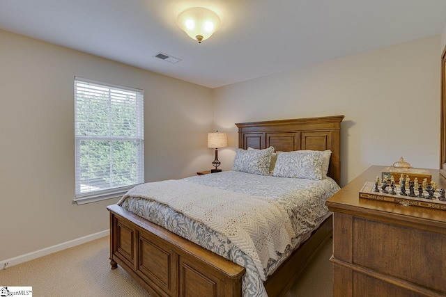 bedroom with baseboards, visible vents, and light colored carpet