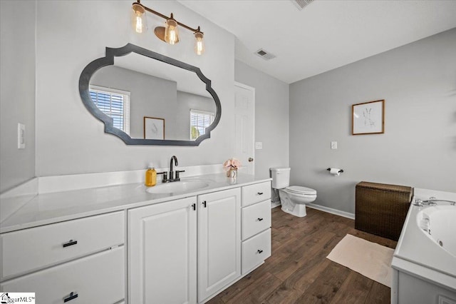 full bathroom featuring visible vents, vanity, toilet, and wood finished floors