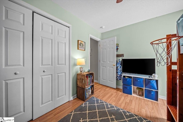 interior space with a textured ceiling, baseboards, and wood finished floors