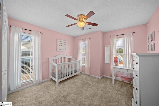 bedroom featuring carpet, visible vents, a ceiling fan, a textured ceiling, and baseboards