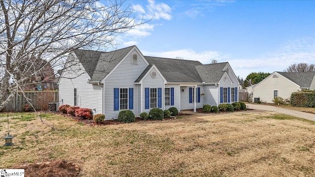 view of front facade featuring fence, a front lawn, central AC, and roof with shingles