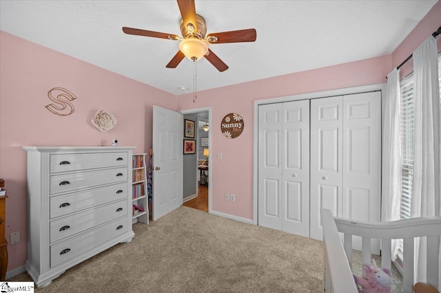 bedroom with carpet floors, ceiling fan, baseboards, and a closet