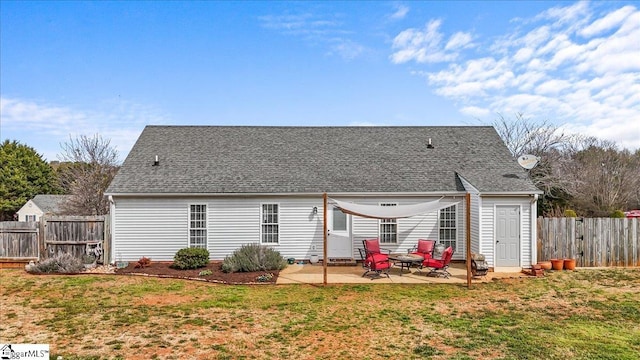 rear view of house featuring a patio area, fence, a lawn, and roof with shingles