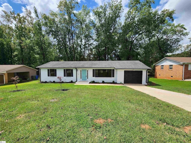 ranch-style home featuring driveway, an attached garage, and a front yard