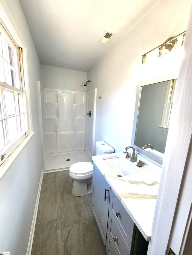 full bath with toilet, vanity, visible vents, baseboards, and walk in shower