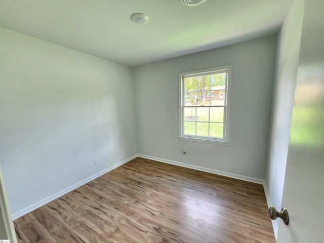 unfurnished room with baseboards and wood finished floors