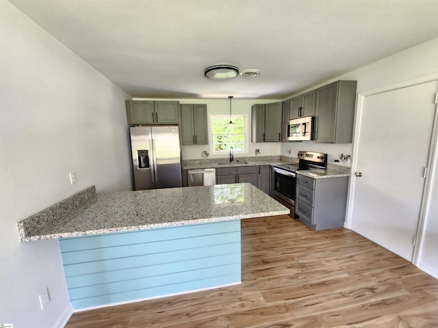 kitchen featuring visible vents, appliances with stainless steel finishes, a peninsula, light stone countertops, and gray cabinetry