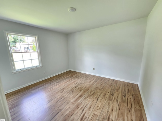 unfurnished room featuring wood finished floors and baseboards