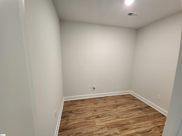 empty room with visible vents, baseboards, and wood finished floors