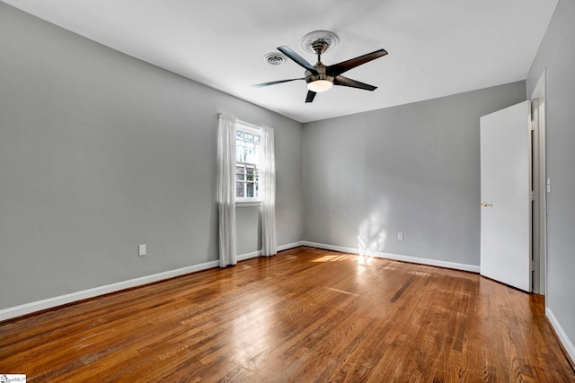 unfurnished room featuring wood finished floors, a ceiling fan, and baseboards