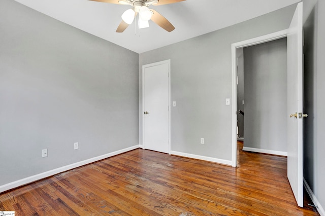 unfurnished bedroom with ceiling fan, wood finished floors, and baseboards