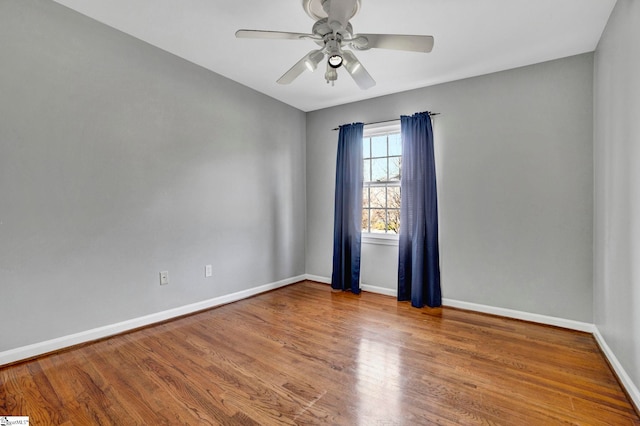 unfurnished room featuring ceiling fan, wood finished floors, and baseboards