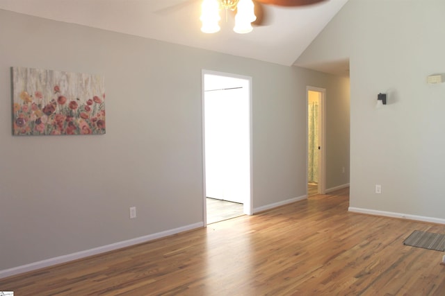 unfurnished room featuring ceiling fan, wood finished floors, lofted ceiling, and baseboards