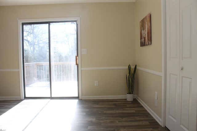 empty room featuring dark wood-style floors and baseboards