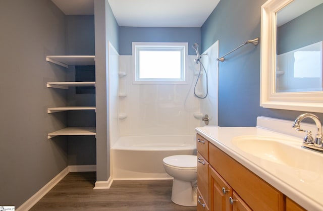 bathroom with toilet, tub / shower combination, vanity, wood finished floors, and baseboards