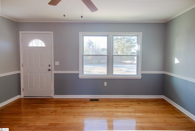 foyer with baseboards, crown molding, visible vents, and light wood-style floors