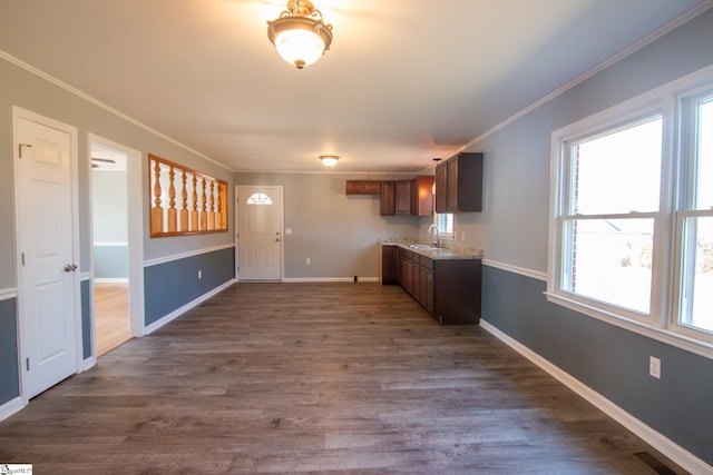 kitchen with dark wood-style floors, baseboards, visible vents, and ornamental molding