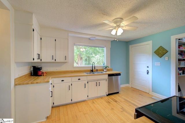 kitchen featuring range, a sink, light wood-type flooring, white cabinetry, and stainless steel dishwasher