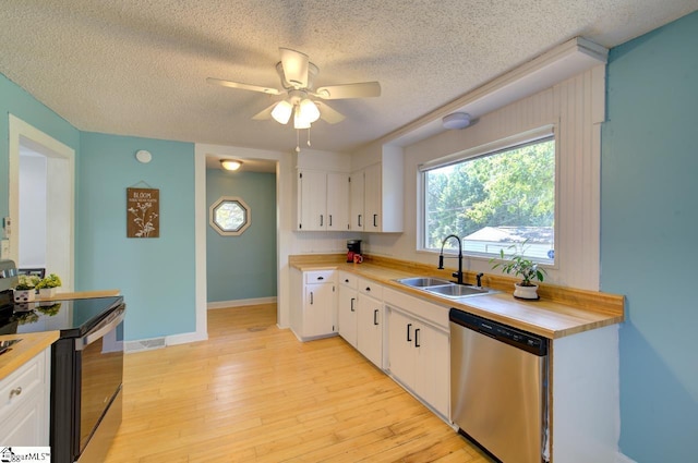 kitchen featuring a sink, white cabinetry, light wood-style floors, stainless steel dishwasher, and electric range oven