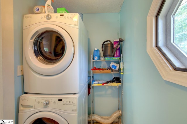 laundry area with a textured ceiling, laundry area, and stacked washer and clothes dryer