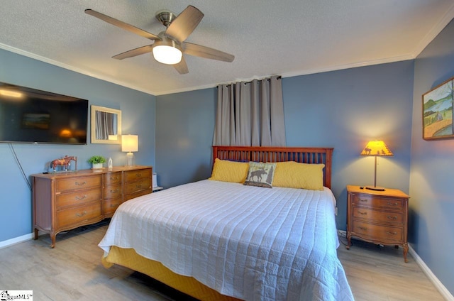 bedroom with baseboards, a ceiling fan, a textured ceiling, crown molding, and light wood-type flooring