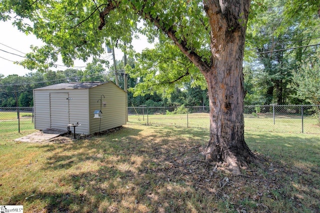 view of yard with a fenced backyard, an outdoor structure, and a shed