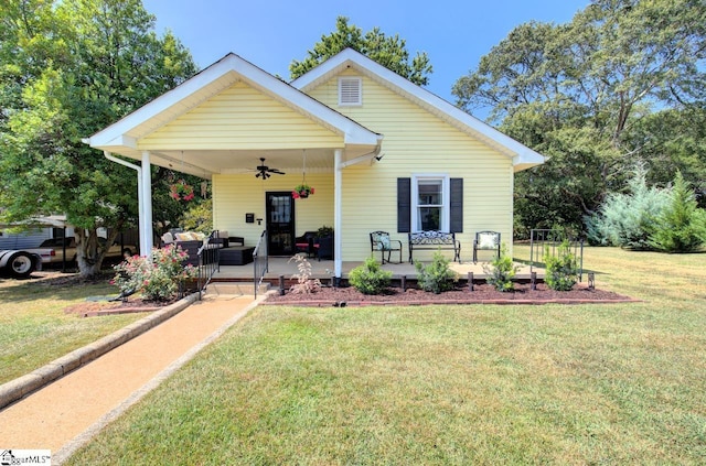 bungalow-style home featuring ceiling fan, a porch, and a front yard