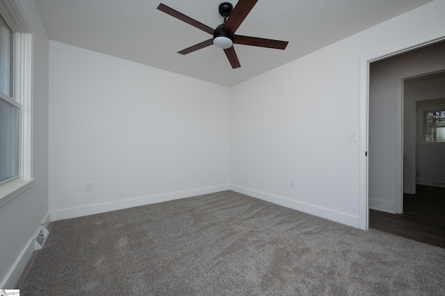 empty room featuring carpet flooring, ceiling fan, visible vents, and baseboards