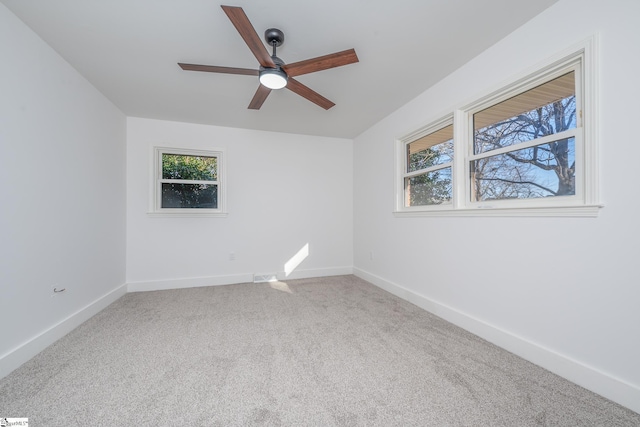 carpeted empty room with ceiling fan and baseboards