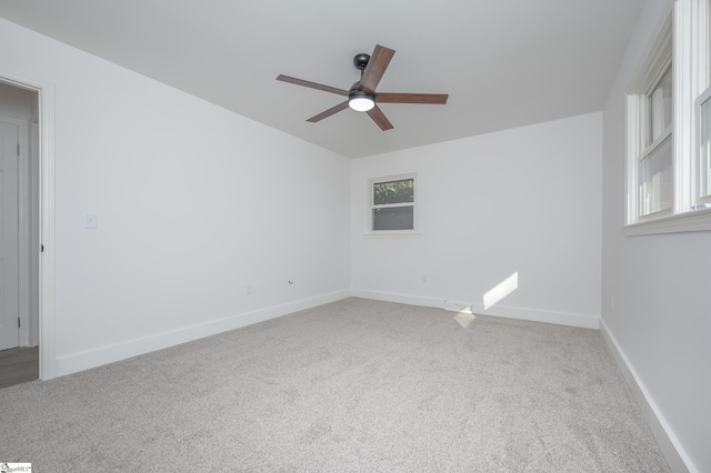 carpeted spare room with ceiling fan and baseboards