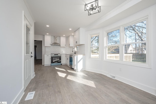 unfurnished living room with plenty of natural light, visible vents, and a sink