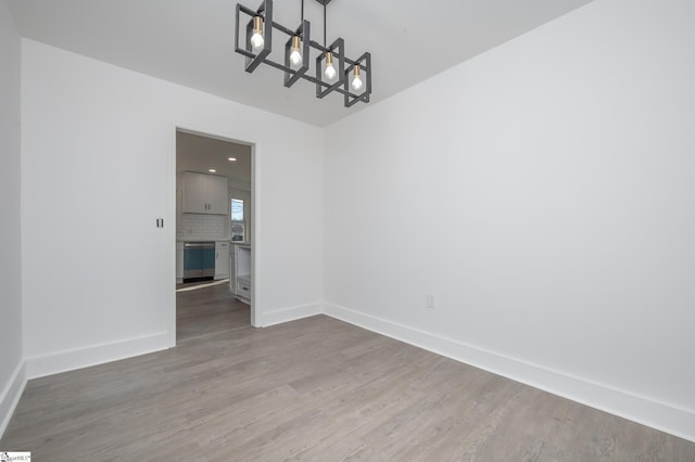 unfurnished dining area featuring wood finished floors and baseboards