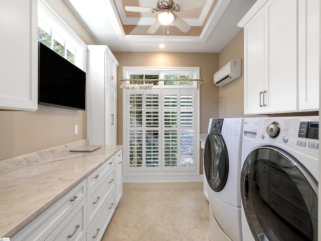 clothes washing area featuring plenty of natural light, washing machine and dryer, cabinet space, and an AC wall unit