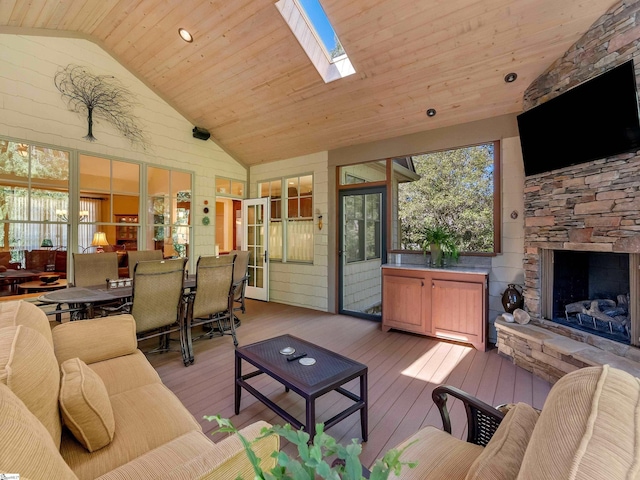 interior space featuring wood ceiling, wood-type flooring, a fireplace, and a skylight