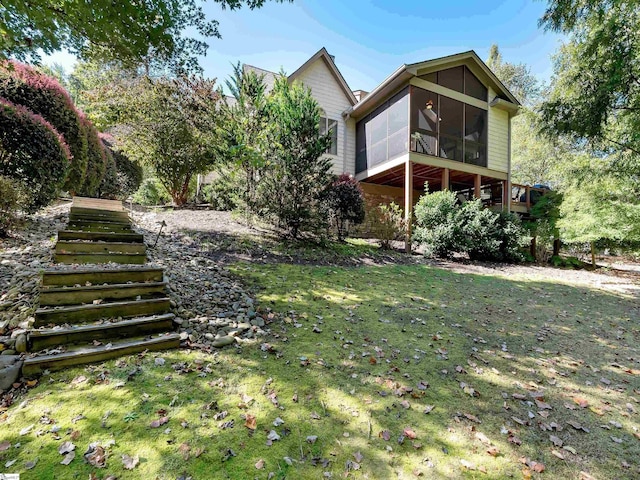 view of yard featuring a sunroom and stairs