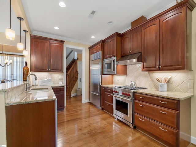 kitchen with visible vents, built in appliances, a peninsula, under cabinet range hood, and a sink