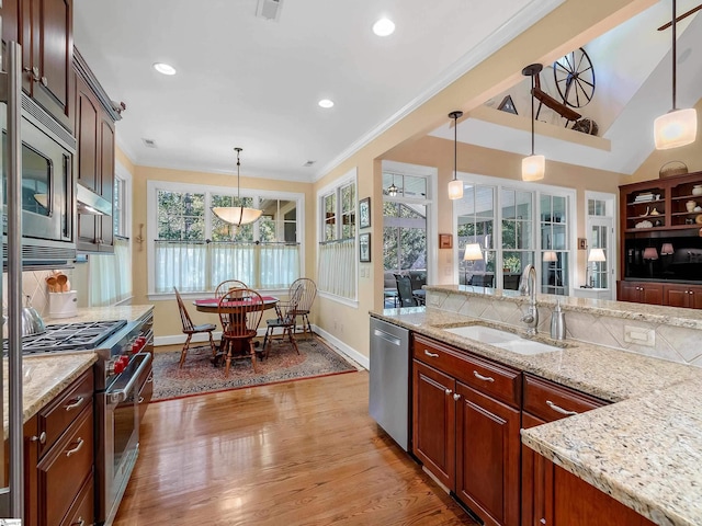 kitchen with stainless steel appliances, tasteful backsplash, light wood-style floors, ornamental molding, and a sink