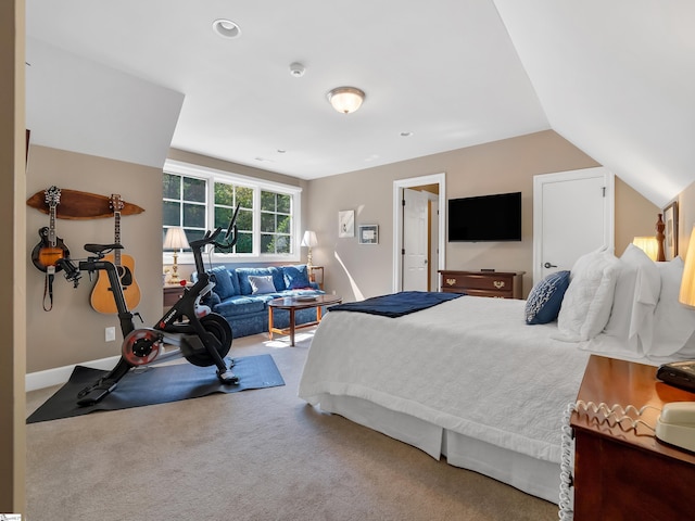 carpeted bedroom with vaulted ceiling and baseboards