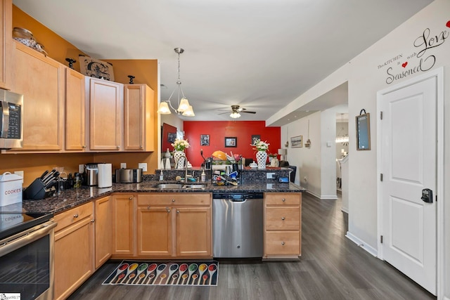 kitchen featuring stainless steel appliances, dark wood-type flooring, a peninsula, a sink, and a ceiling fan