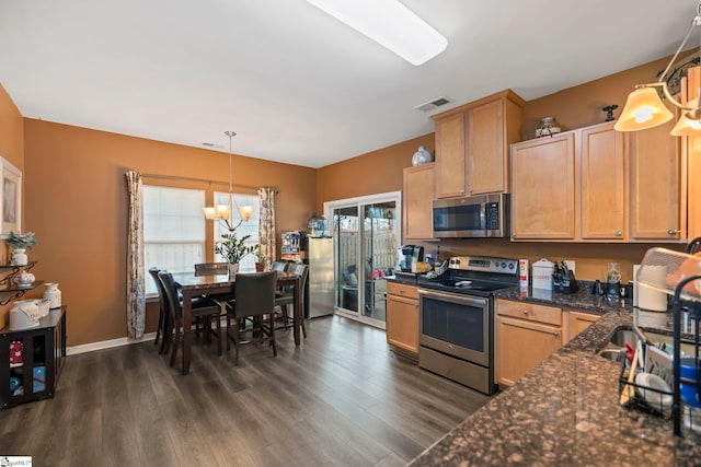 kitchen with dark wood-style flooring, decorative light fixtures, visible vents, appliances with stainless steel finishes, and a sink