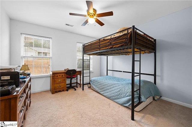 carpeted bedroom featuring baseboards, visible vents, and ceiling fan