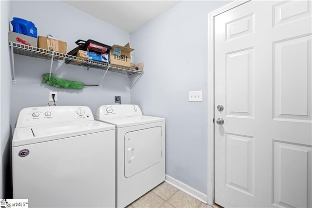 washroom featuring light tile patterned floors, laundry area, independent washer and dryer, and baseboards