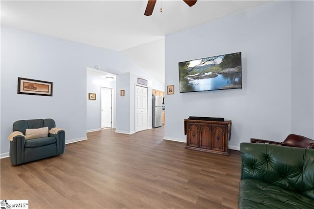 sitting room with a ceiling fan, lofted ceiling, baseboards, and wood finished floors